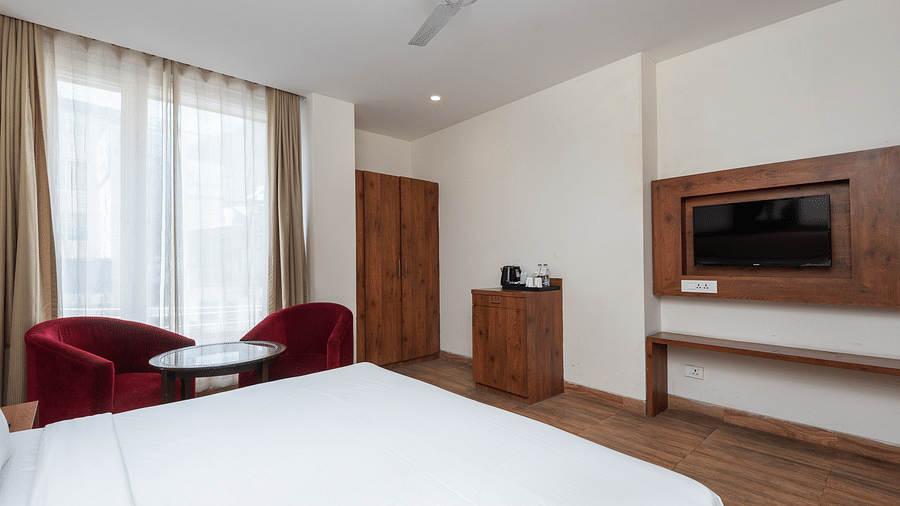 Premium room featuring a television, wooden wardrobe, a cosy table with two chairs at DLS The Classio